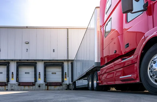 Semi truck connected to a trailer at a loading dock
